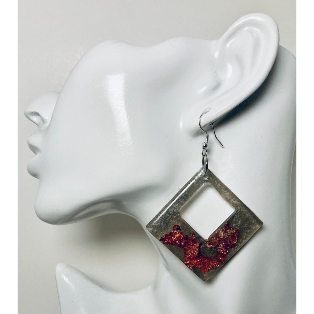 A diamond shaped earring with copper imitation flakes embedded for the obvious sparkle. Avail. in two flake colors: Smoky Copper (shown) and a Gold Frost option. Approx. 2 3/4" in size not including the Sterling silver ear wire.