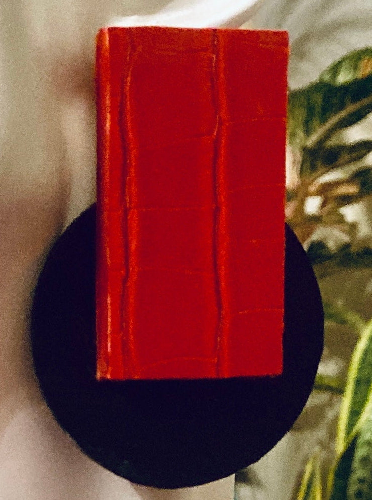 A pair of geometric drop earrings displayed on a white mannequin head. The earrings feature a large, textured red rectangular top section mounted on a round black base, set against a white background.