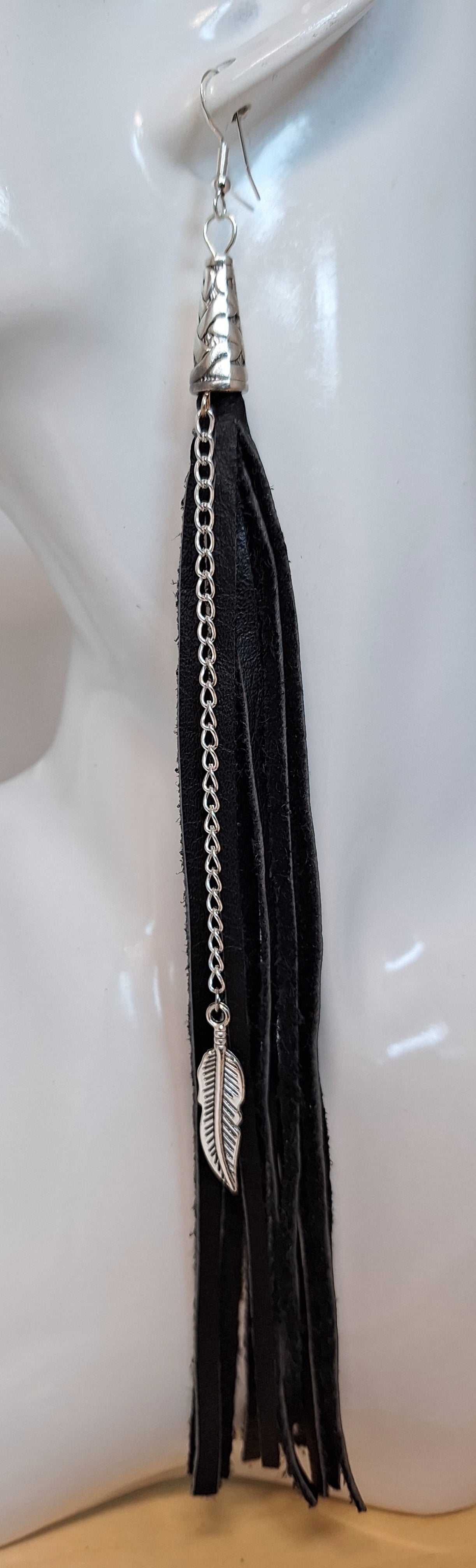 These are a style spin on our Black Leather Tassel earrings (1/4").
The Spaghetti Tassel is 1/8" wide, the same genuine leather however, they are paired with a stainless steel chain and a 1" metal leaf.
Measurements: 7 1/2" long not including the Sterling silver ear wire.