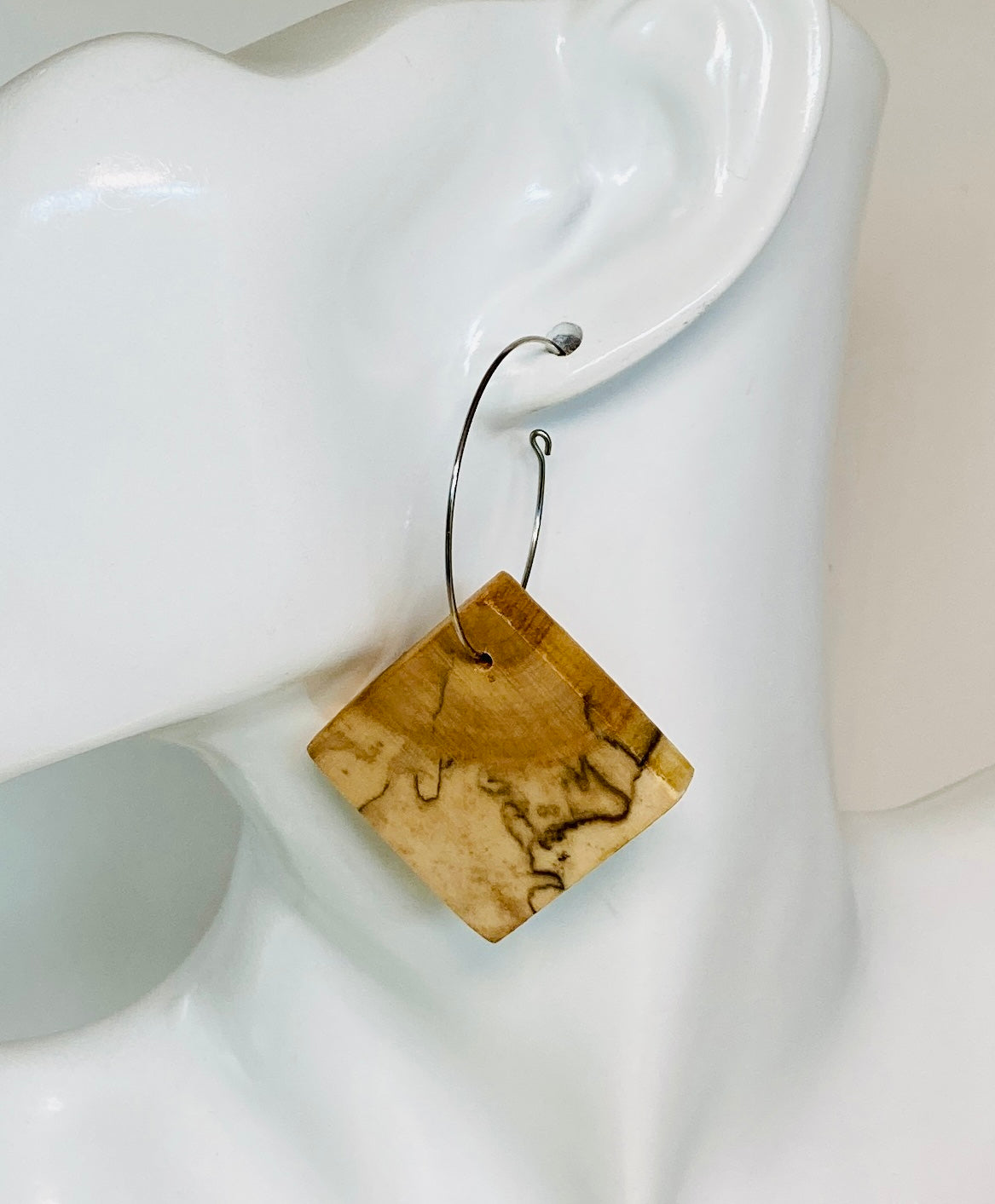 These authentic wooden earrings are made from Spalted Birch Exotic Wood. The wood is cut and book-matched more precise image. Nature dictates that no two pair of this design is exactly alike. Measuring 1" square (approx.) and paired with a 1 1/4" stainless steel hypoallergenic hoop. 