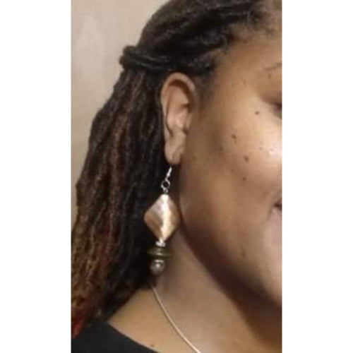 Copper Divine Earrings were made using semi precious stones and a copper distressed main bead that is approx. 1 1/4". The main attraction in this picture is the textured diamond shaped copper earring that is hallow and paired with a flying saucer shaped bead. Next, the marbleized semi-precious 10mm bead "rounds" it out. Save $5.00 when you purchase both as a set. The full earring measures 2 1/4". They are finished with the Sterling silver ear wire.