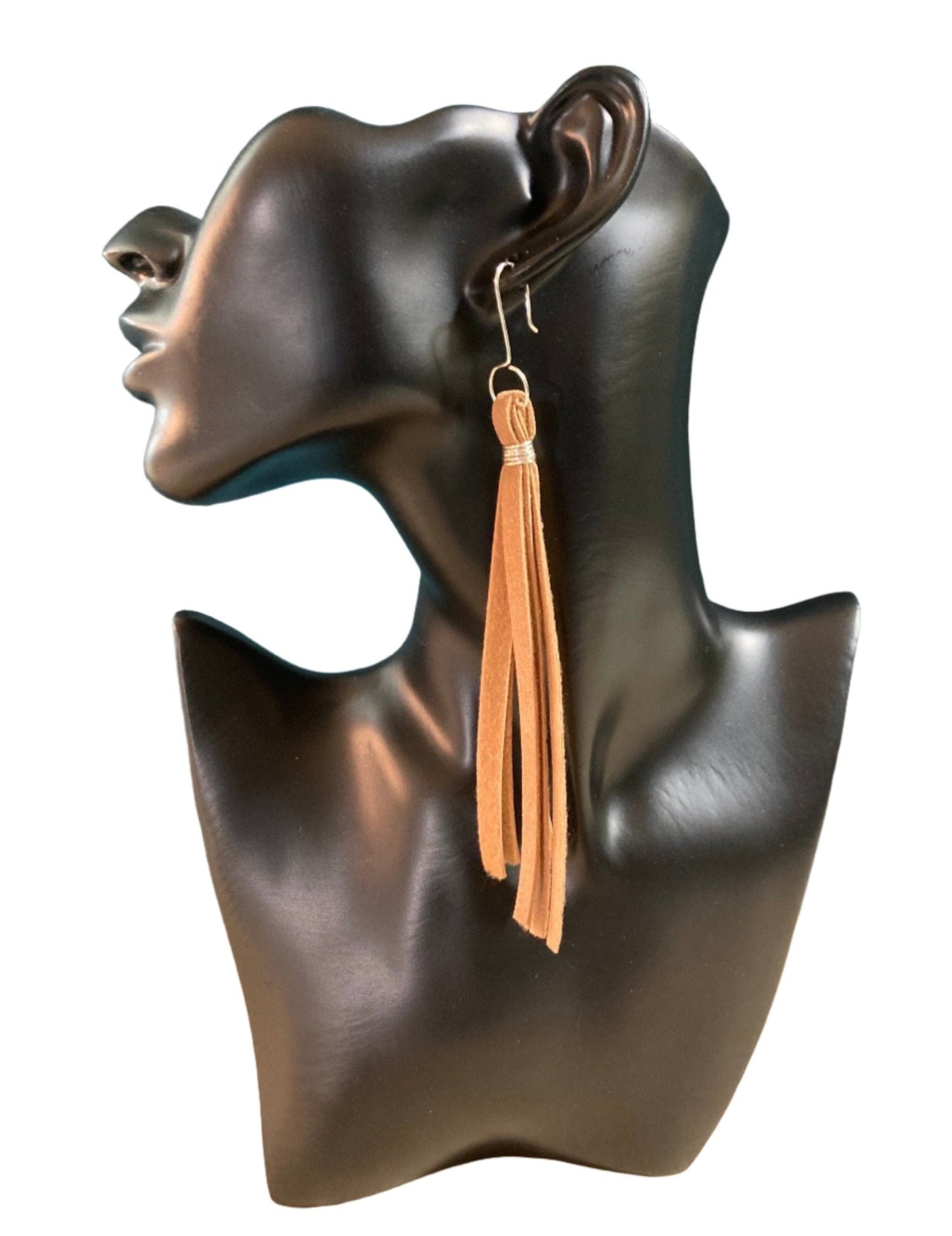 A 5" Suede-look Lasso Tassel Earring. 1/4" wide with a soft backing. These earrings are similar to the barrel hook earrings; we just thought it would be nice to give another "top end" option, so we designed an Urban/Country look. A lasso-look ear wire.