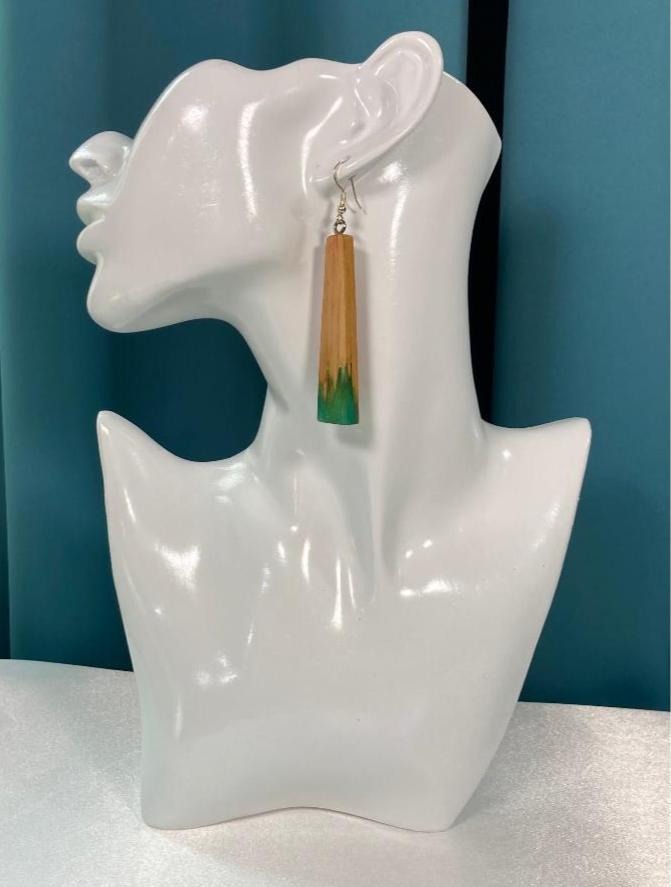 The Wood Fusion Earring, is made using maple wood that is a rectangular shape and is narrower at the top (1/4" diameter) and gradually sized to approx. 3/4" at the bottom. A dyed resin/powder is poured in the mold that is poured at the bottom. This item is emerald green. Finished with Sterling silver ear wires.
