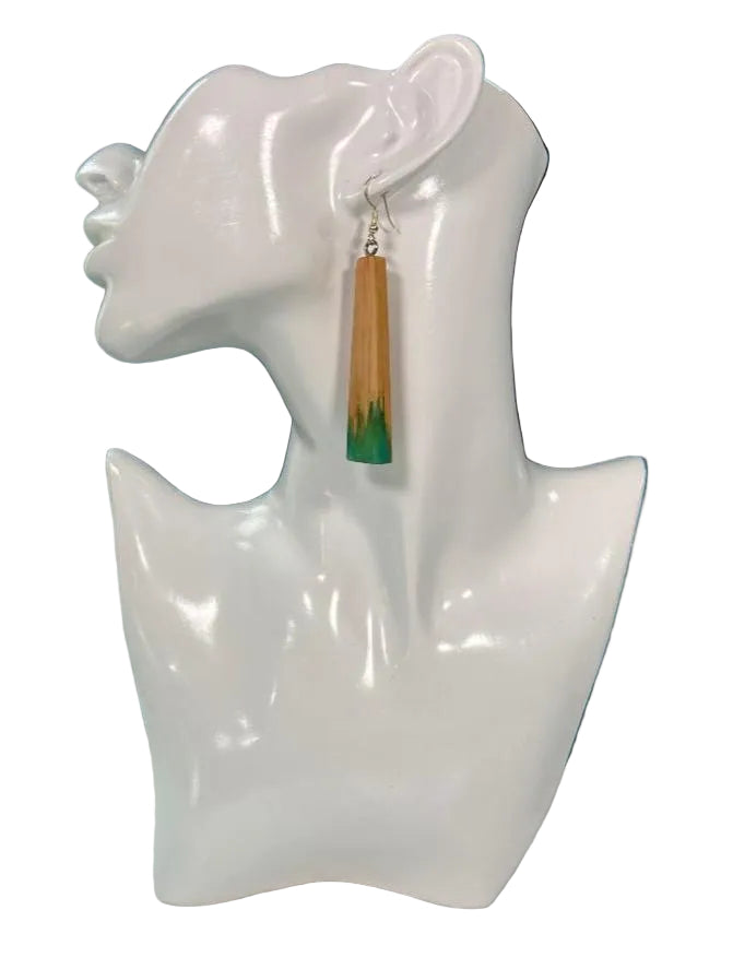 The Wood Fusion Earrings, are made using maple wood that is a rectangular shape and is narrower at the top (1/4" diameter) and gradually sized to approx. 3/4" at the bottom. A dyed blue/green powder is poured into the mold at the bottom where the wood was carefully broken to a jagged inside. Finished with Sterling silver ear wires.
