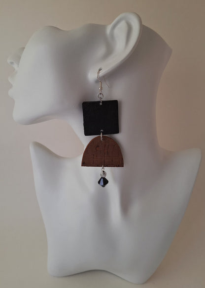  A textured black square paired with a curved brown cork accent, silver bead, and black glass drop on a white mannequin head. Crafted with hypoallergenic ear wires for comfort and designed to be an affordable everyday staple at $15.00.