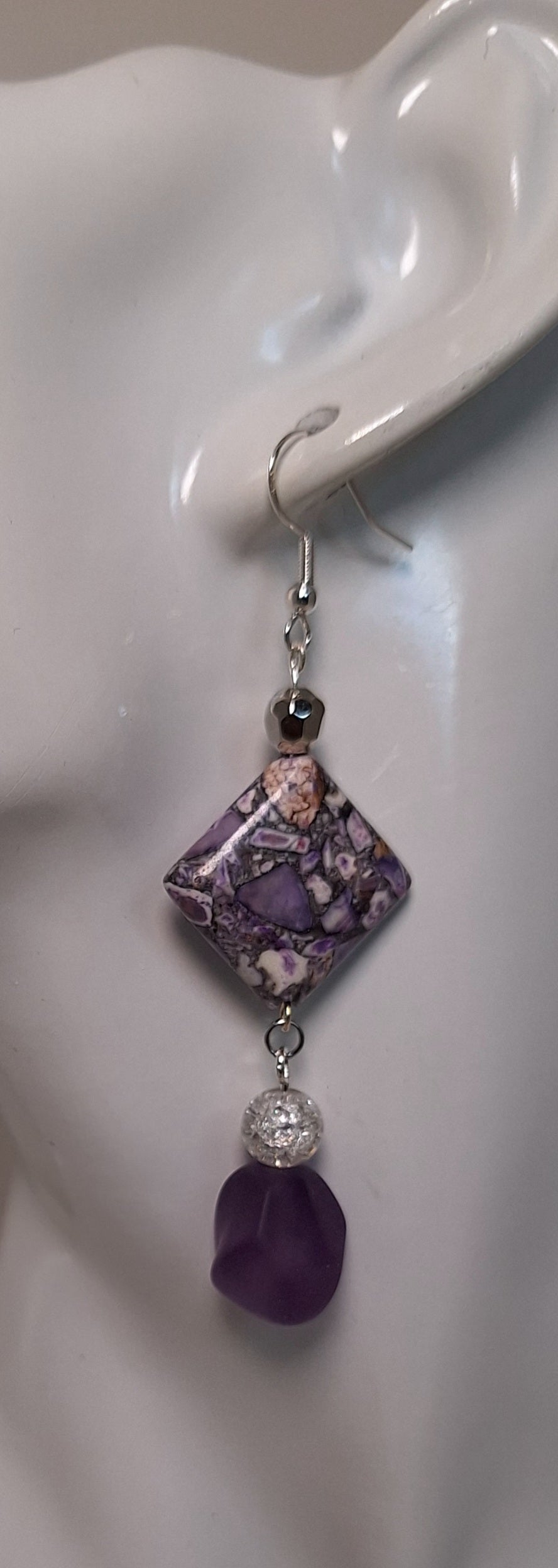 The design includes 1 diamond shaped printed, 1 coordinating frosted, 1 cracked glass and 1 silver bead.
Measuring approx.&nbsp; 2" not including the Sterling silver ear wires.&nbsp;