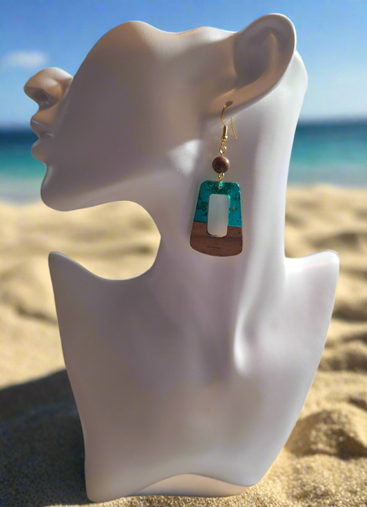 These earrings are made of turquoise colored resin acrylic with gold flakes inserted, with a 1/4" driftwood-look bead for a perfect complement. Finished with durable gold plated ear wires.&nbsp;
Measurements: 1 1/2" (approx.)