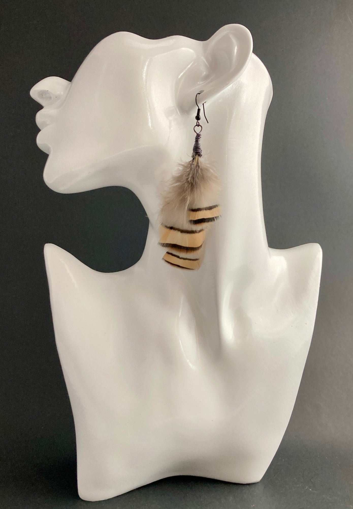 (Backdrop #2) Feather-Neutral Earrings. Sophisticated and alluring, this pair will surely take your style to the next level. Colors include Smoke, Gold and Black. Paired with bronze hypoallergenic wires.